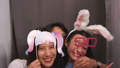 group of young friends having fun posing in photo booth with props shot in real time 2