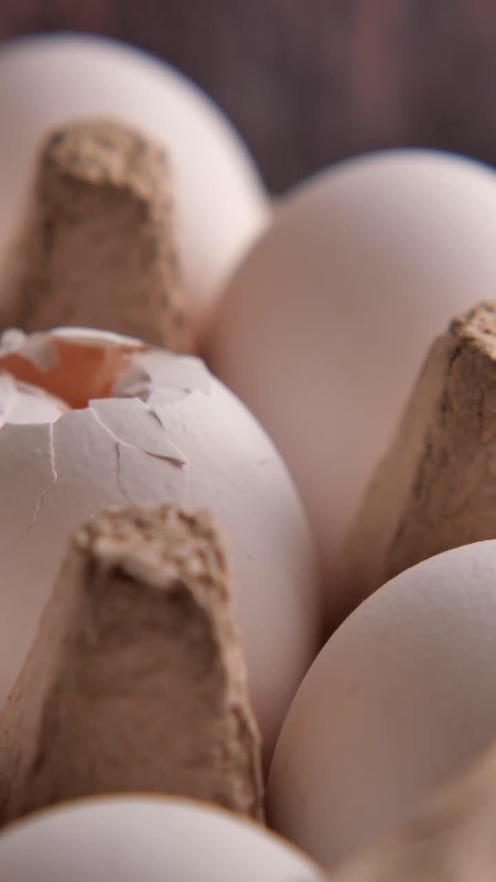 Close Up of White Eggs in a Carton with One Cracked