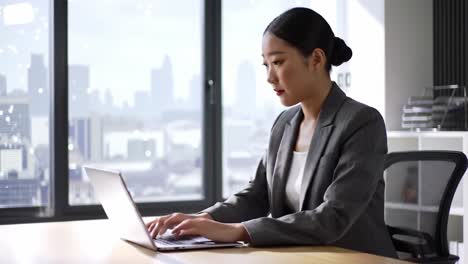 Focused Professional in Modern Office Setting with Urban View, Engaged in Thoughtful Work on Laptop, Reflecting Contemporary Work Culture and Ambition