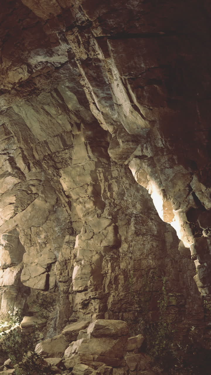 Exploring a hidden cave illuminated by natural light in a remote location