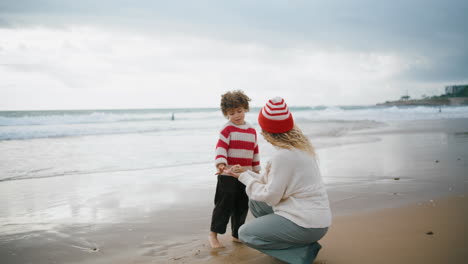 Niñera-Enseñando-A-Un-Niño-Pequeño-En-La-Playa-De-Otoño.-Hermosa-Madre-Soltera-Jugando