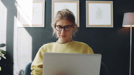 mujer trabajando en una computadora portátil en casa