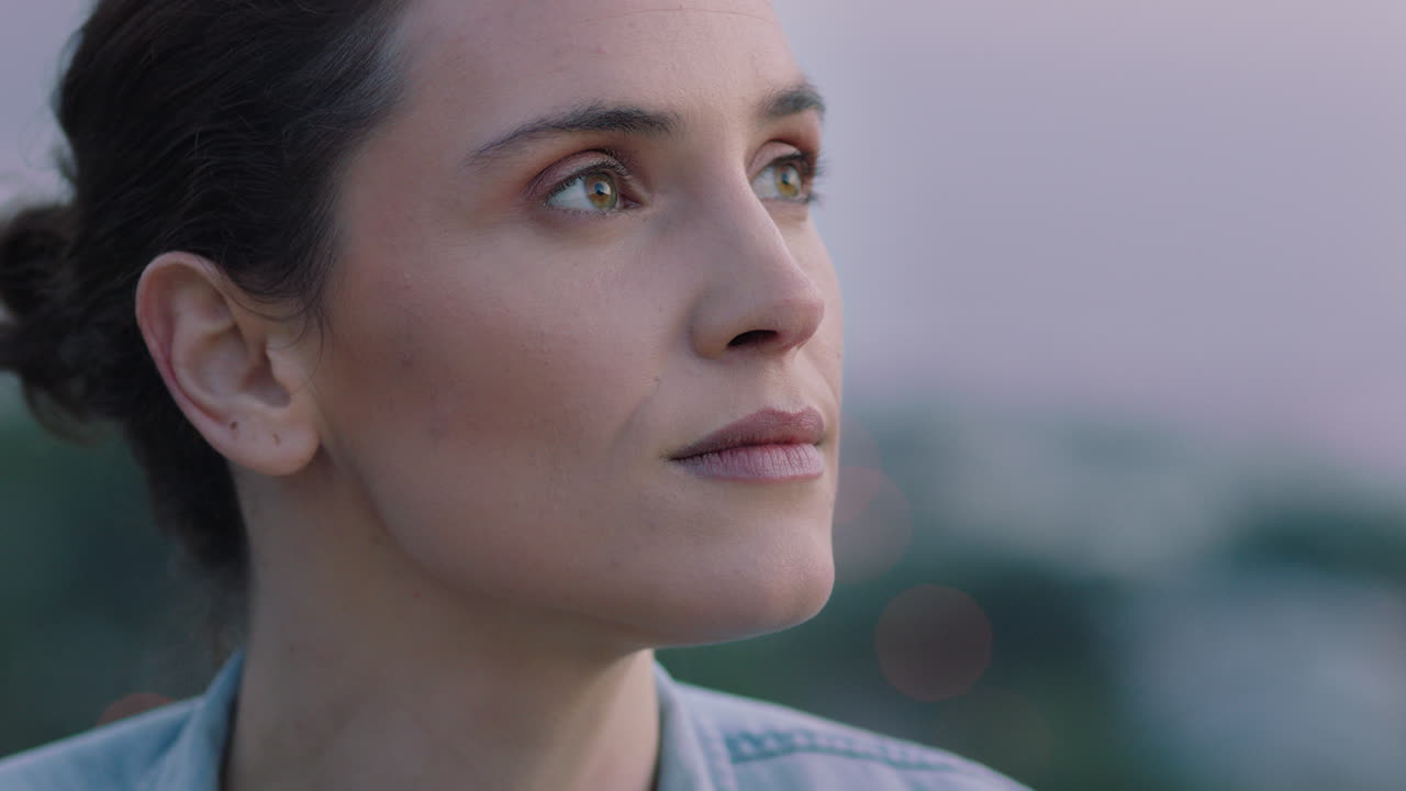 retrato de cerca de una mujer hermosa explorando la espiritualidad mirando hacia arriba orando contemplando el viaje con el viento soplando el cabello en el campo disfrutando de una tranquila puesta de sol