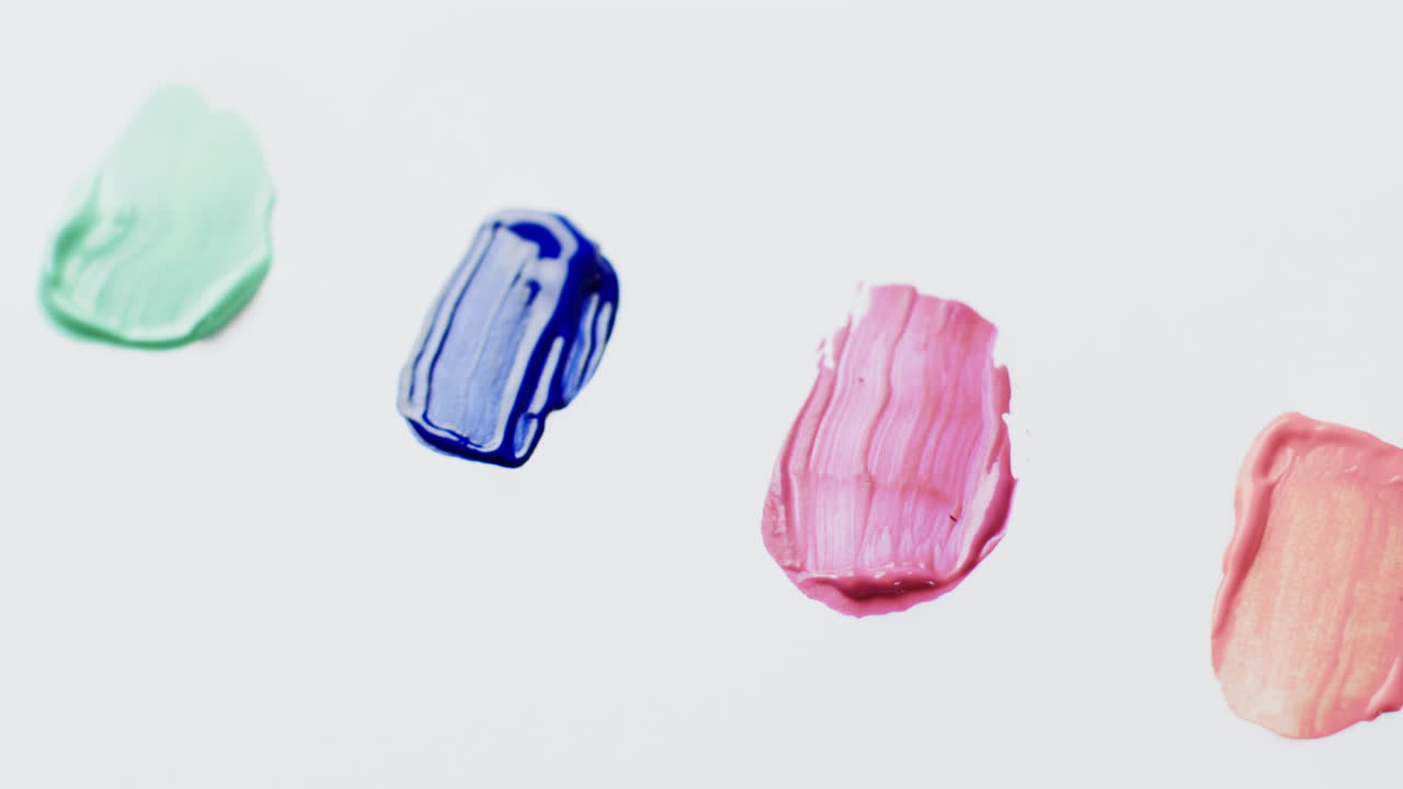 primer plano de formas de pintura multicolores sobre fondo blanco con espacio de copia, cámara lenta