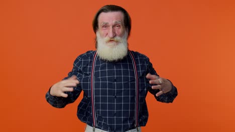anciano divertido hombre señalando con el dedo a la cámara, riendo en voz alta de apariencia ridícula, broma divertida