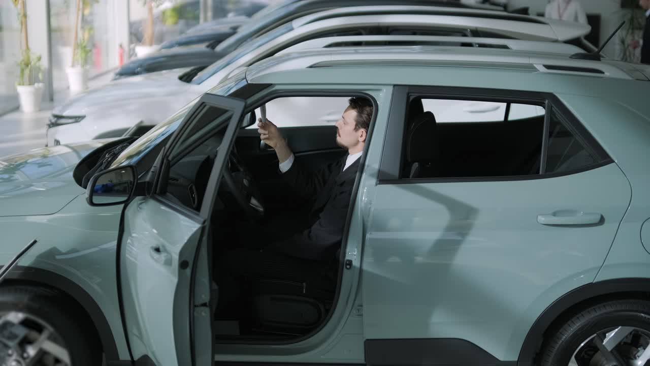 Man checking out a new car in a dealership