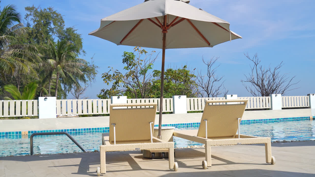 바다를 배경으로 한 수영장 주변의 빈 침대 수영장 - 공휴일 및 휴가 개념