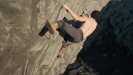 a young asian male is rock climbing in iceland during daytime