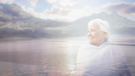 animation of glowing light over portrait of happy senior woman