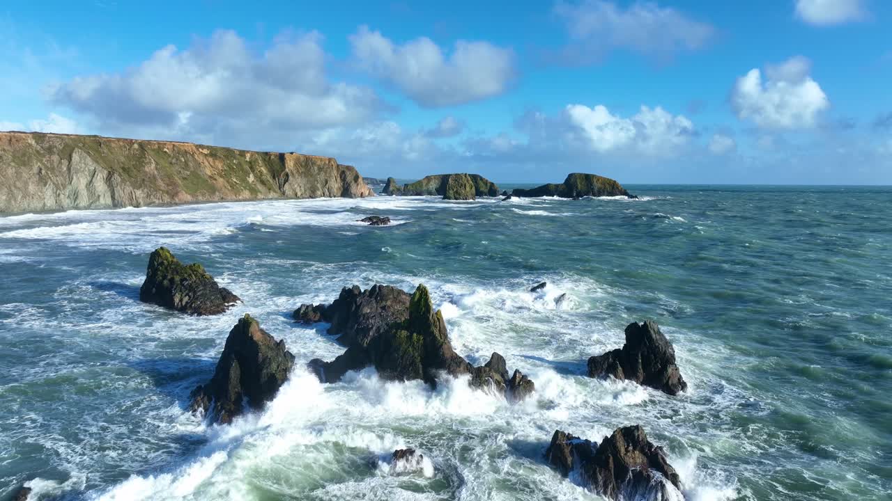 Epic Ireland winter Atlantic Storm drone flying over reef with rough turquoise seas Copper Coast Waterford