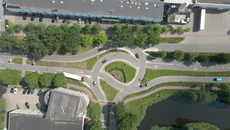 Top-down-aerial-of-cars-driving-over-busy-intersection---drone-lifting-up