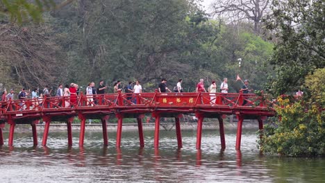 crowd crossing red bridge in hanoi, vietnam