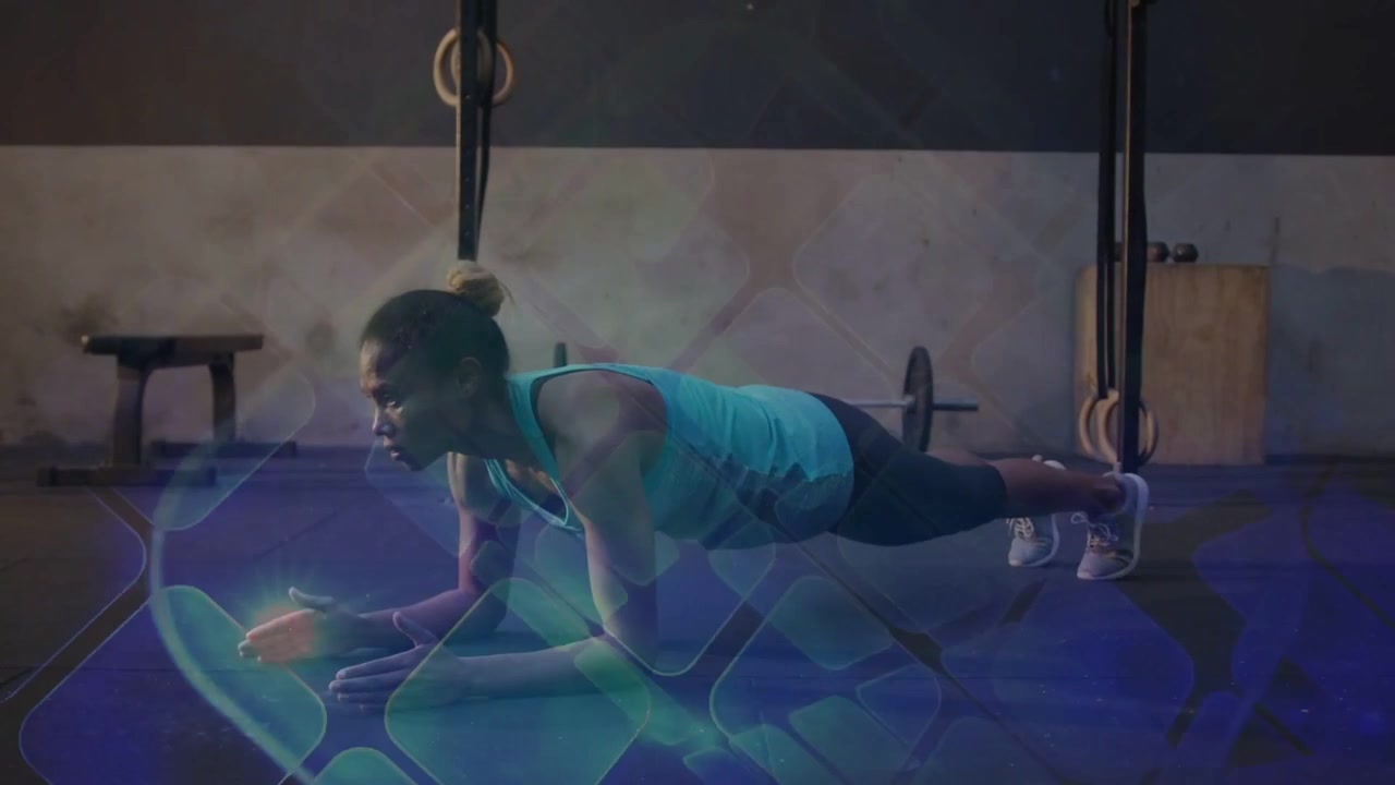 Vertical video: Shifting woman lowering from high plank to elbows at gym, core tight in tank, rings