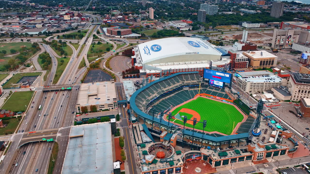 Detroit, USA, 11 August 2025: Vibrant aerial view of Comerica Park in Detroit. Green-domed baseball stadium surrounded by green fields and highways under overcast light