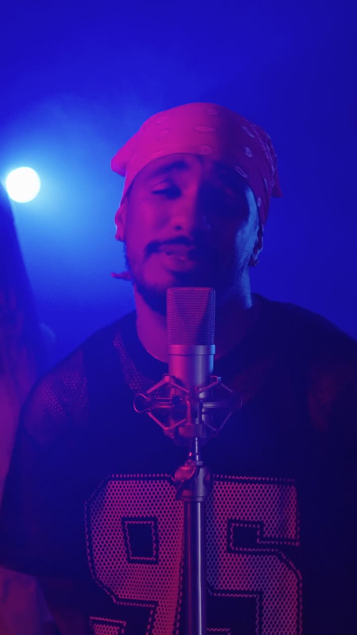 Man singing into a microphone wearing a bandana