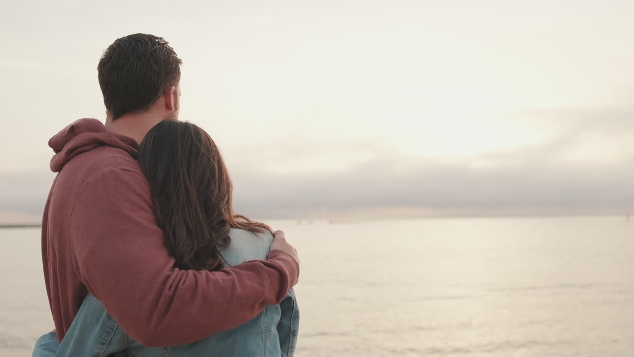 Romantic couple embracing on the beach at sunset