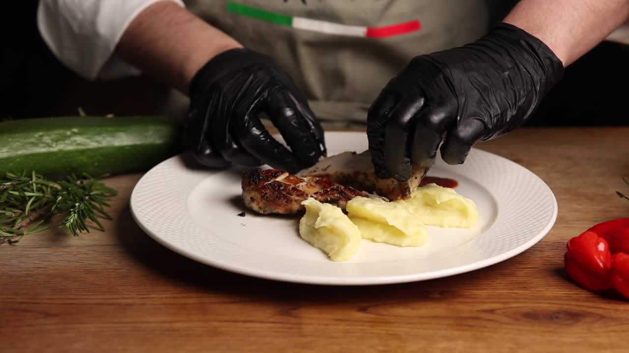 Chef Plating a Gourmet Meal with Chicken and Mashed Potatoes
