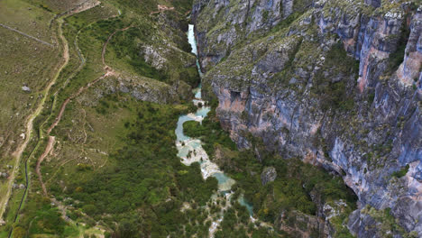 hermoso zoom en drone tomado en el lago millpu con aguas turquesas ubicado en ayacucho, perú con montañas y vegetación alrededor