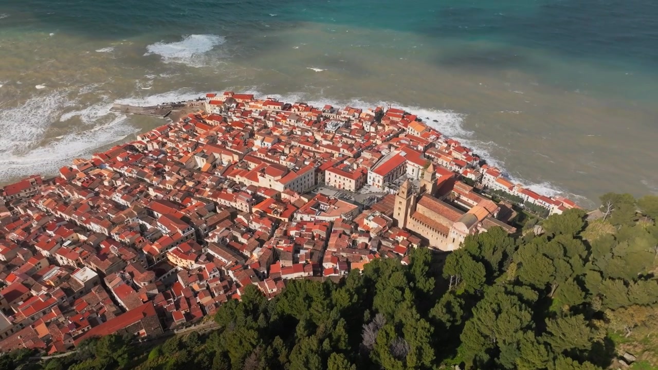 Paesaggio aereo di Cefalù ripreso da drone con rovine di un castello storico su una montagna rocciosa e la costa del centro storico, Cefalù, Italia, Sicilia