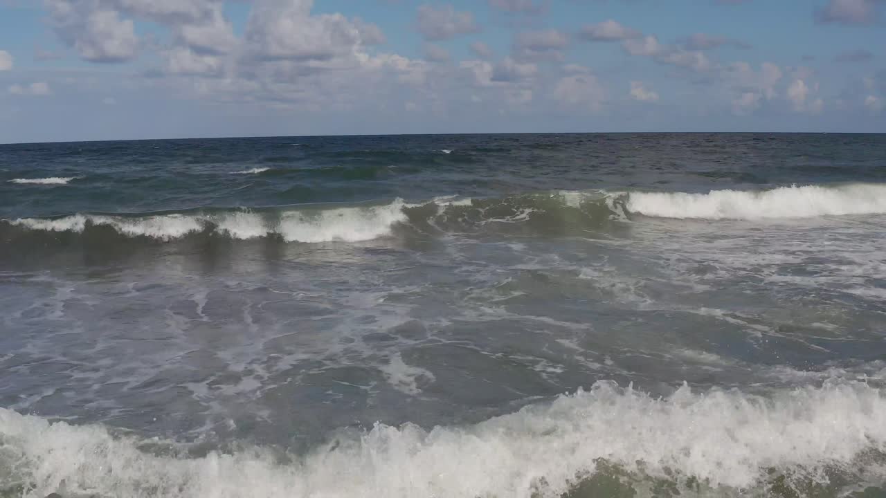 крупный план движение назад вдоль волн, разбивающихся о берег