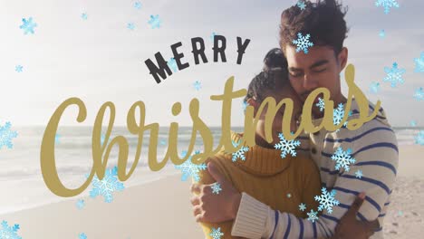 Animation-of-merry-christmas-text-and-snow-falling-over-biracial-couple-at-beach