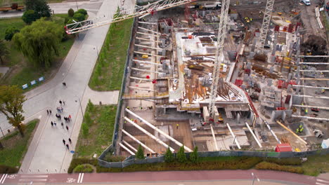 Die-Nach-Oben-Geneigte-Luftaufnahme-Zeigt-Hochhauskräne-Im-Stadtzentrum