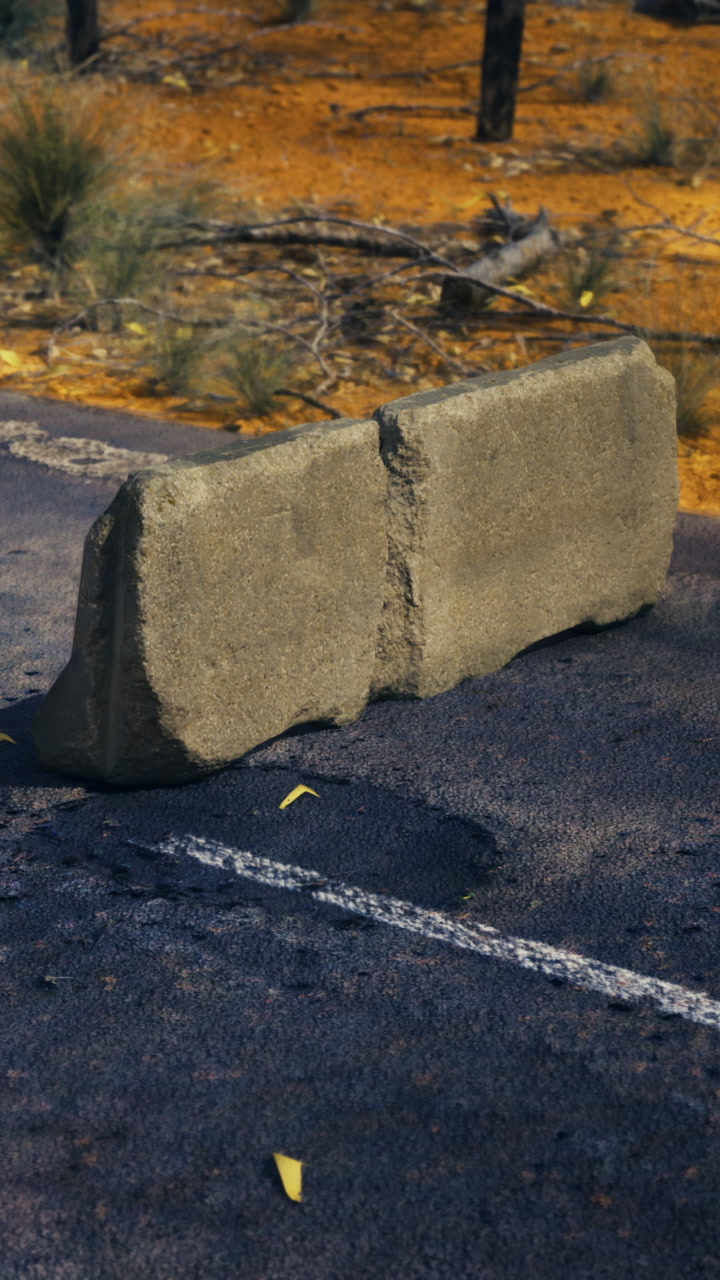 Unique stone barrier rests on a sun kissed rural road in australia