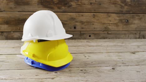 video of close up of colourful building helmets on wooden background