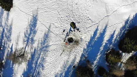 un dron cinematográfico lento voló hacia arriba, mirando un campamento en medio de la nieve en la cima de una montaña