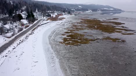 Vista-De-Drones-De-Un-Pequeño-Pueblo-En-La-Orilla-Del-Río-San-Lorenzo-En-Invierno