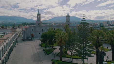 tomas aéreas de drones sobre calles y vegetación que conducen a la catedral de arequipa, concluyendo con una vista del volcán misti cubierto de nieve después de un día lluvioso y nublado