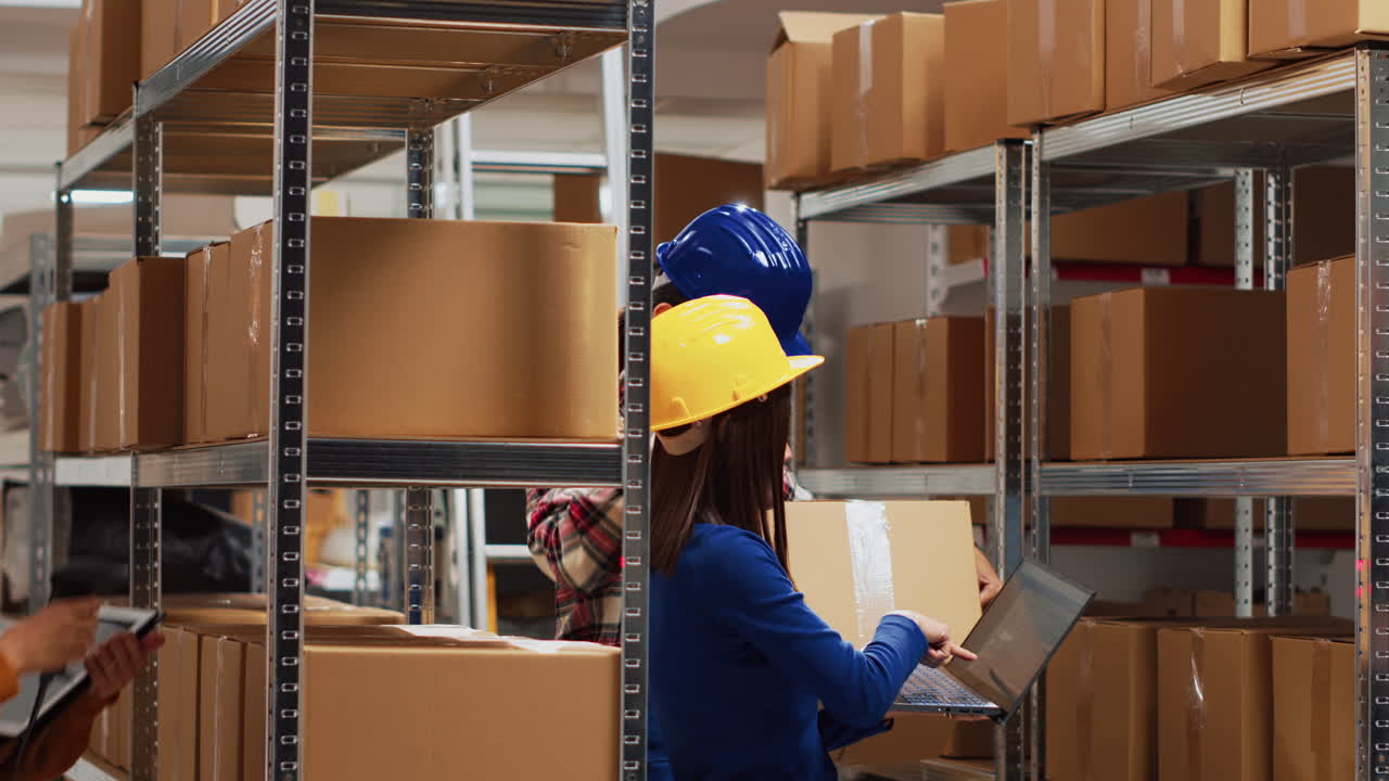 Warehouse workers managing inventory with scanners and laptops