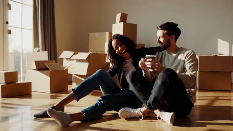 happy couple relaxes and laughs in their new home after moving