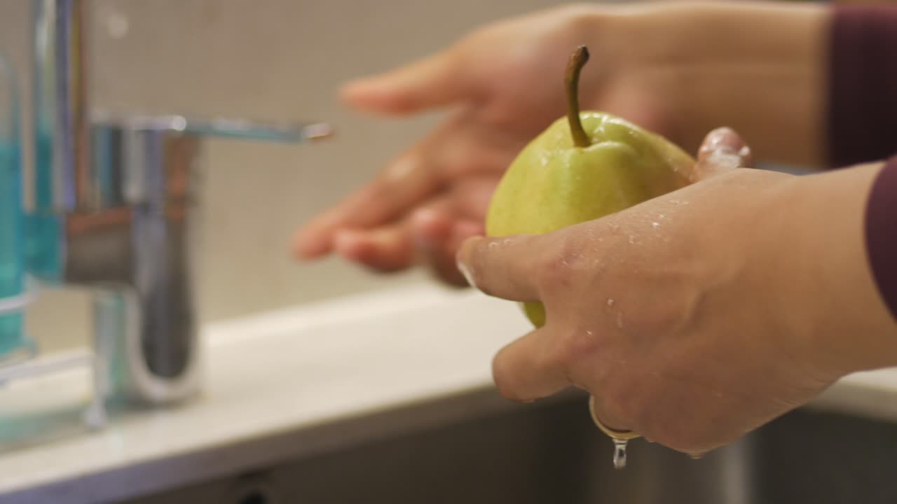 Lavando fruta bajo agua corriente