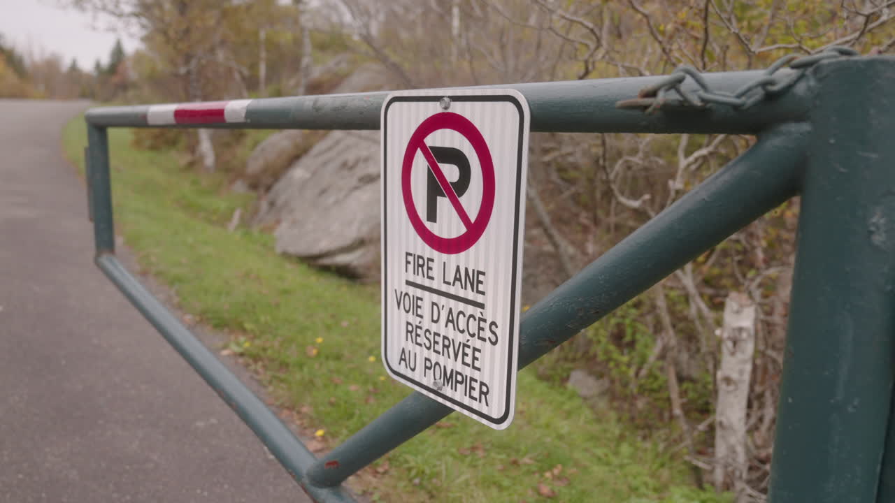 No Parking Fire Lane sign on a park entrance road gate
