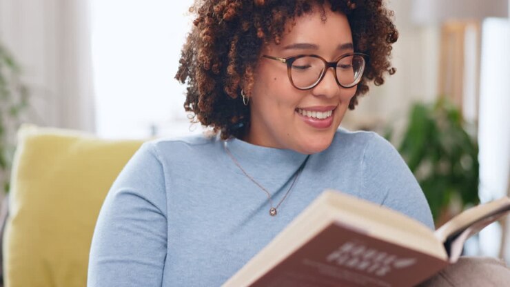Relax, book and female reading on a sofa