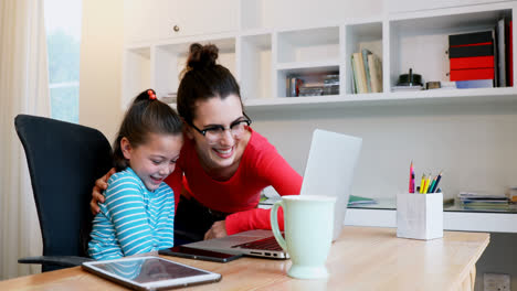 Madre-Ayudando-A-Su-Hija-A-Usar-Una-Computadora-Portátil-4k