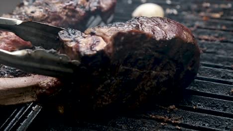 placing juicy tomahawk steak on hot grill