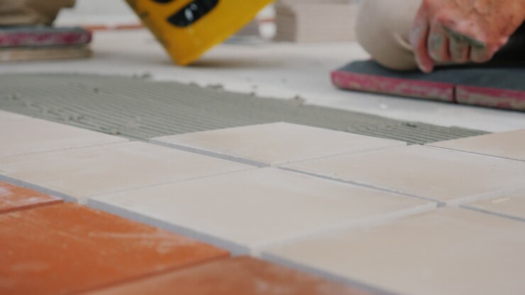 Workers Laying Tile On The Floor Close-