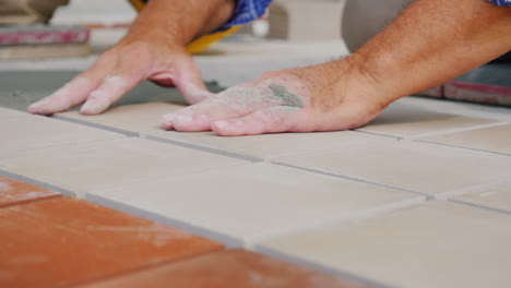 workers laying tile on the floor close-