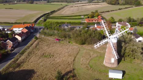 billingford windmill at farmland area with house and roads in diss, norfolk - aerial drone flying tracking shot