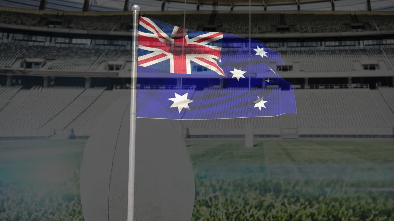 Waving Australian flag over empty stadium with green field and seating