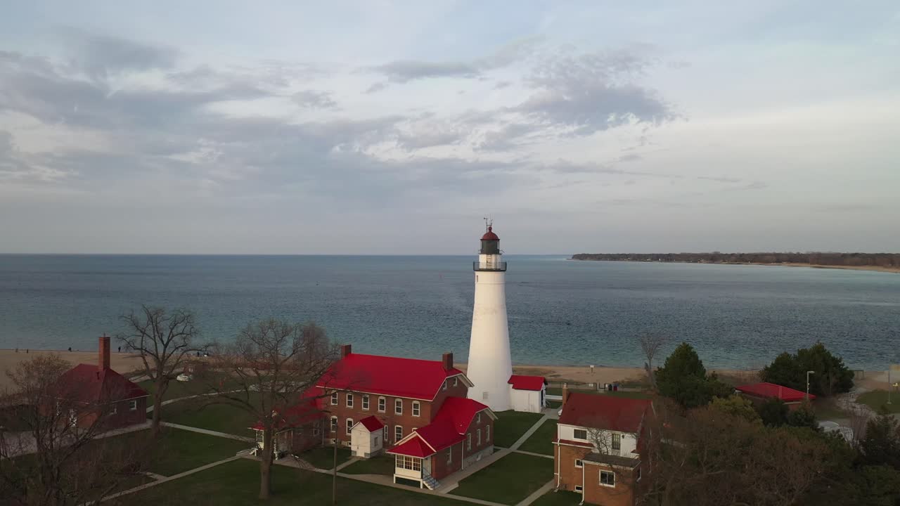 Fort Gratiot Lighthouse in Port Huron, Michigan in the evening with drone video moving up