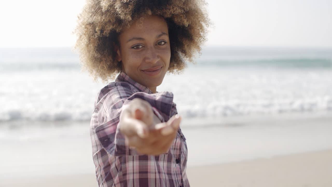 mujer feliz dando la mano en la playa
