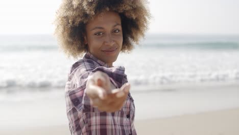 happy woman giving hand on beach