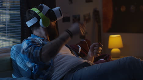 man using vr headset in bedroom at night