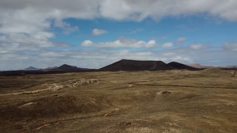 drone shot flying over lava fields and volcanic plains in lanzarote