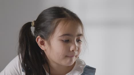 studio portrait of shy and uncertain young girl against white background