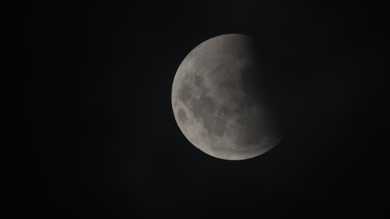Close up shot of the moon in the nights sky during a lunar eclipse, complete black sky
