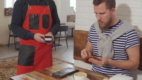 cliente pagando en la cafetería con tarjeta de crédito